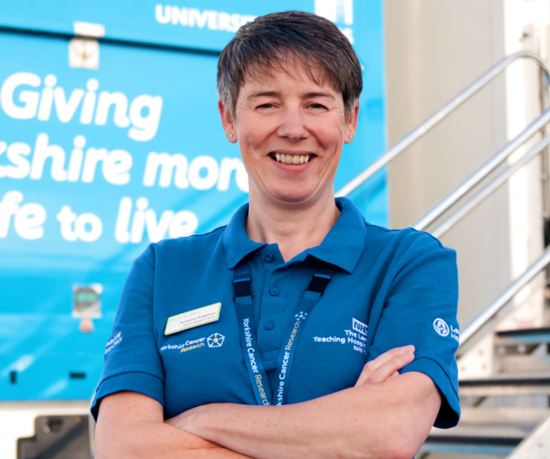 Female practioner wearing Yorkshire Cancer Research polo shirt with arms crossed